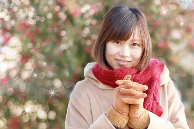 手を組んで微笑む女性